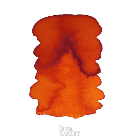 NG Special '16 - 2ml ink sample featuring a warm reddish-orange hue with a darker edge, displayed on paper with THE DESK BANDIT watermark.