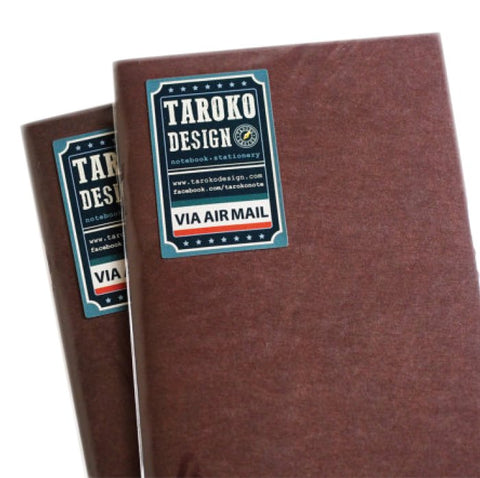 Two slim Tomoe River Insert - Passport notebooks with plain brown covers, featuring blue-and-white TAROKO DESIGN labels and red-white-blue VIA AIR MAIL stripes.