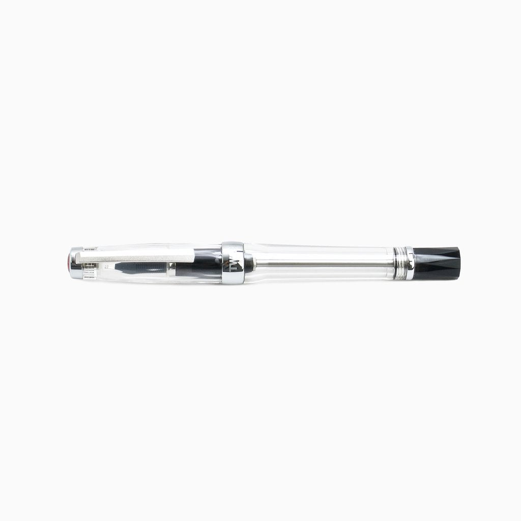 VAC 700R (Clear) - Extra Fine fountain pen with a transparent barrel, chrome-plated trim, black piston knob, and screw-on cap, showcasing its vacuum filling system.