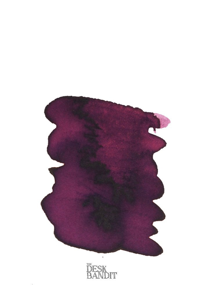 Swatch of Rohrer & Klingner Alt-Bordeaux ink sample, showcasing its plum-toned hue with granulation, accompanied by The Desk Bandit logo, highlighting its fountain-pen suitability.