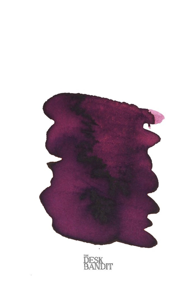 Swatch of Rohrer & Klingner Alt-Bordeaux ink sample, showcasing its plum-toned hue with granulation, accompanied by The Desk Bandit logo, highlighting its fountain-pen suitability.