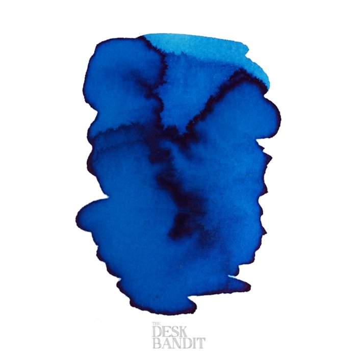 Abstract swatch of Robert Oster's Australian Sky Blue ink, showcasing deep cobalt tones with darker gradients. Watermarked by The Desk Bandit, indicating a 50ml dye-based ink sample.