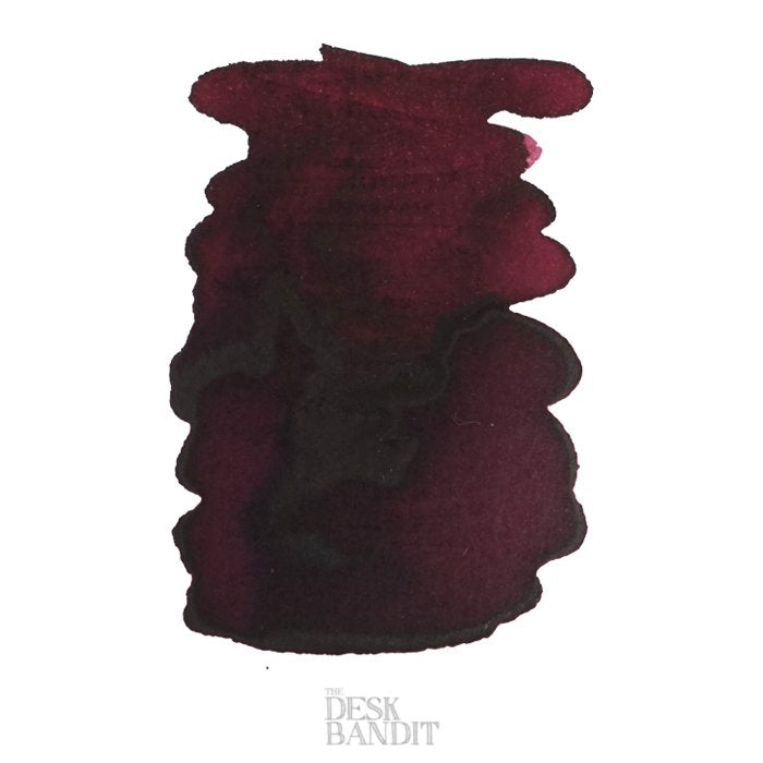 Australian Syrah - 2ml ink sample, showing a burgundy-red hue with darker center shading on white paper, featuring The Desk Bandit watermark at the bottom.