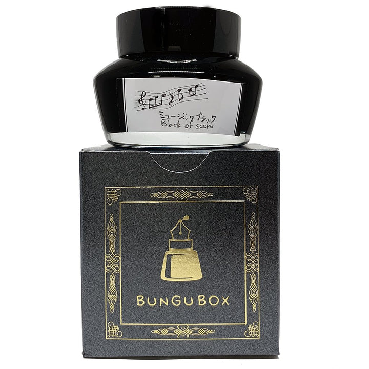 Bungubox Black of Score fountain-pen ink, 2ml, in a bottle with a musical-themed label, sits atop its elegant black-and-gold packaging box.