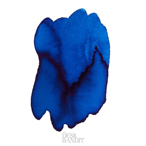 Blue Lagoon - 2ml ink sample, featuring an abstract blot of bright blue with darker purplish gradients, showcasing Robert Oster's dye-based ink. Watermark: THE DESK BANDIT.