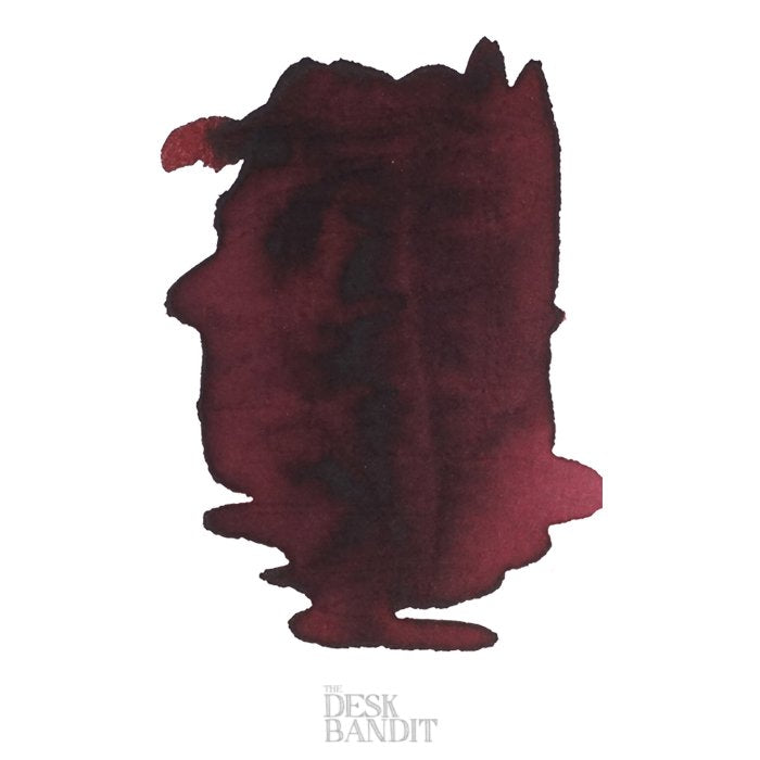 Dark burgundy-red ink swatch on white paper, showcasing Robert Oster's Chocolate - 50ml, with tonal variations and “The Desk Bandit” watermark visible.