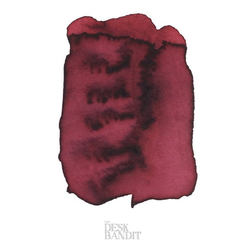 Swatch of Robert Oster's Copper - 2ml ink, displaying rich shading and pooling effects, with faint THE DESK BANDIT branding on white paper.