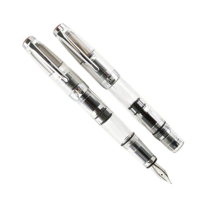 Diamond Mini (Clear) - Stub 1.5 fountain pen showcasing a transparent body, visible piston-fill mechanism, with one pen capped and the other displaying its steel nib.