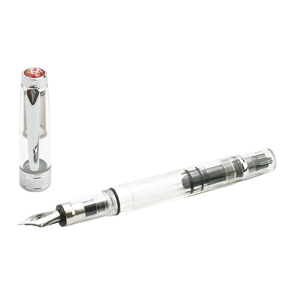 Diamond 580 (Clear) - Stub 1.5 fountain pen with transparent body, visible piston-filling mechanism, stainless-steel nib, and silver-toned cap beside it.