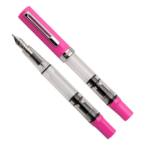 ECO (Pink) - Broad: Transparent piston-filling fountain pen with bright pink cap and tail, clear barrel showing piston mechanism, steel nib visible with cap removed.