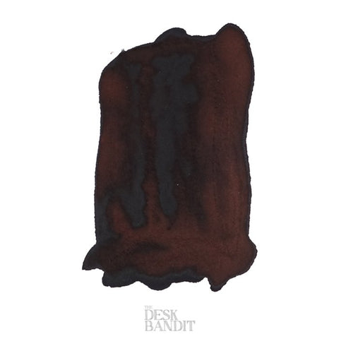 Close-up of a dark brown ink swatch labeled The Desk Bandit, showcasing the Robert Oster Golden Brown - 2ml fountain pen ink sample on white paper.