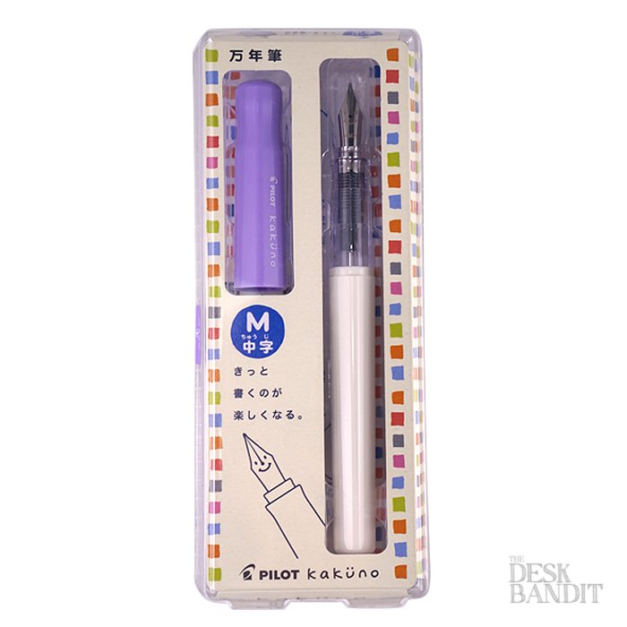 Kakuno - Soft Violet - Medium: Boxed Pilot beginner fountain pen with purple cap, white barrel, medium nib, and smiley nib logo, packaged in Japanese.