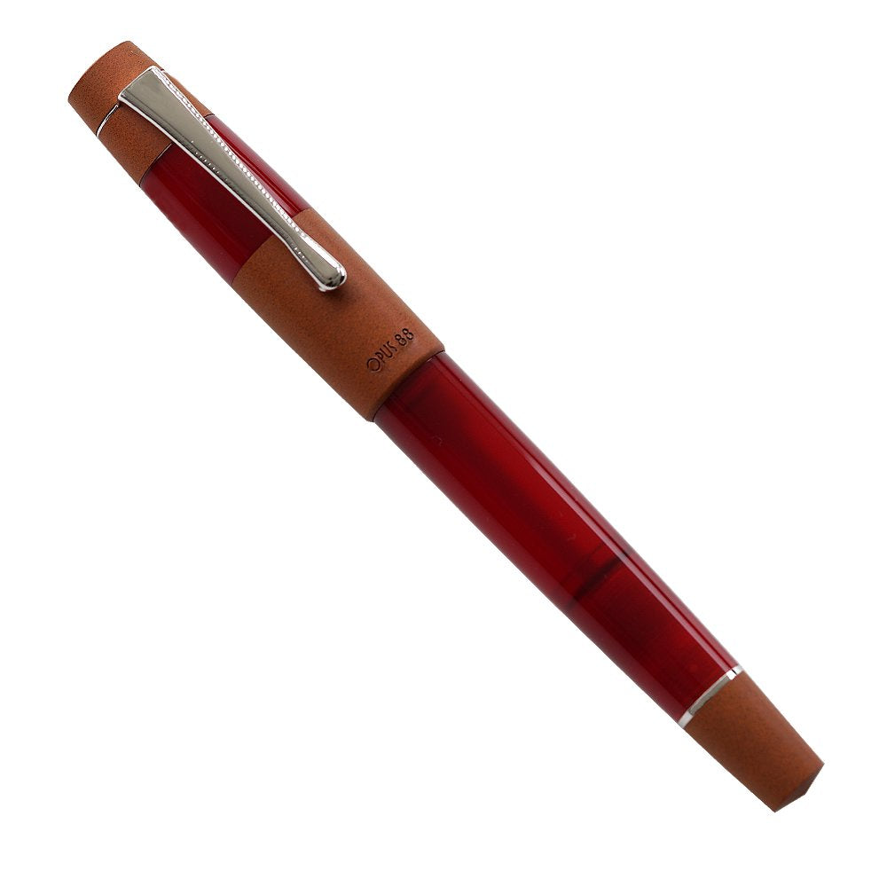 Opus 88 Koloro (Red) fountain pen with a translucent barrel, warm brown grip, chrome-plated clip, and #5 German nib, featuring an eyedropper filling mechanism.