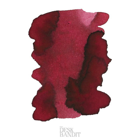 Lipstick Red - 2ml ink sample featuring a burgundy-red blot with darker edges by Robert Oster, logo THE DESK BANDIT at the bottom.