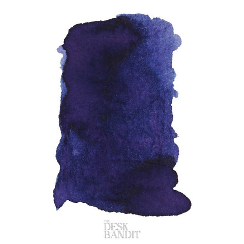 Midnight Sapphire - 2ml ink sample featuring a dark blue–purple, granulating swatch on a white background, branded faintly with THE DESK BANDIT.
