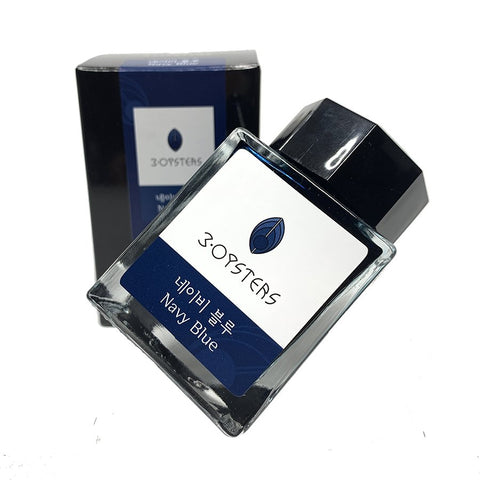A glass bottle of 3Oysters Navy Blue ink, 38ml, with a tilted stand design, alongside its matching box in the background.