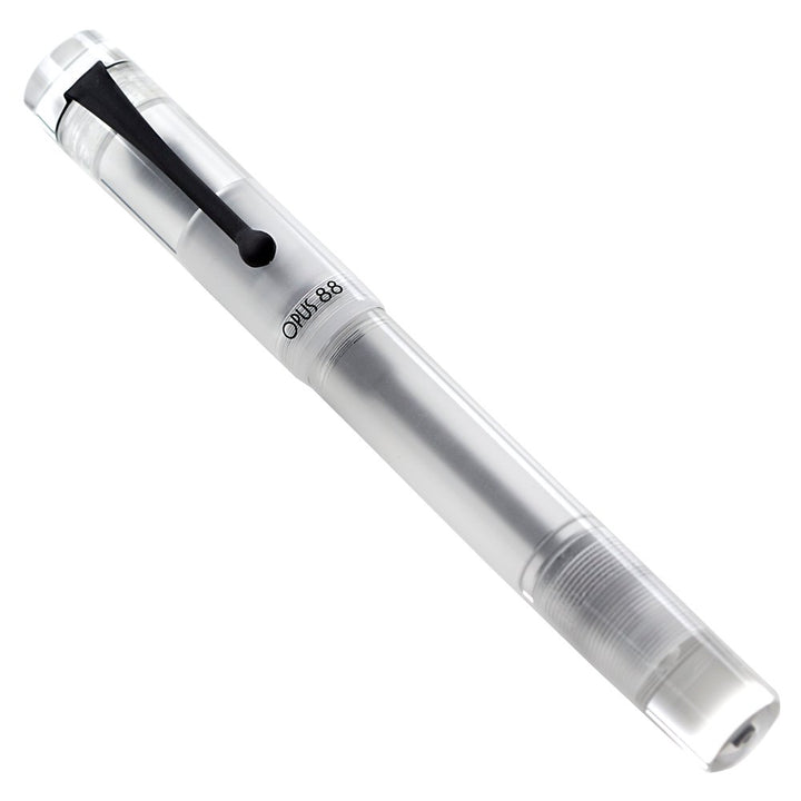 Opus 88 Koloro Demonstrator (Clear) fountain pen, showing a clear acrylic body with black clip and broad #6 German nib, includes an eyedropper tool.