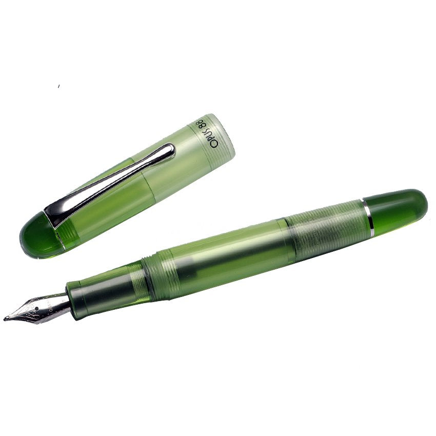 Translucent Opus 88 Picnic - Green fountain pen uncapped, showcasing a broad #5 JoWo steel nib and green cap with chrome clip beside it.