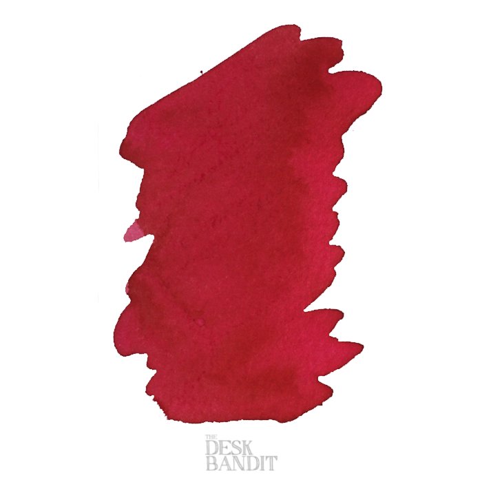 Robert Oster's Pinky - 2ml ink sample, shown as a hand-brushed red swatch on white, featuring The Desk Bandit logo below.