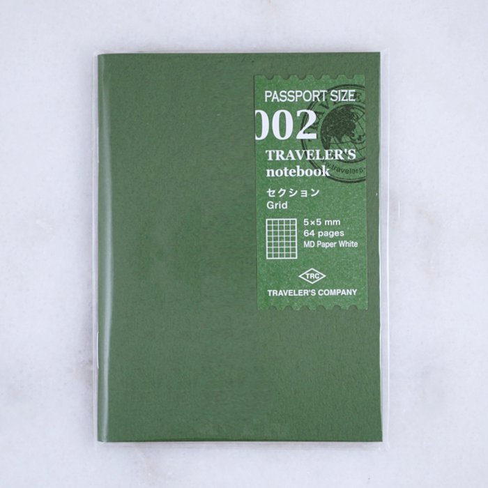 Traveler’s Company #002 Grid (Passport) refill notebook with forest-green cover, featuring 64 MD white paper pages in a 5x5mm grid layout.