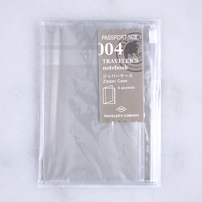 #004 Zipper (Passport) is a clear, passport-sized plastic pouch by Traveler’s Company, featuring a zipper slot and four card-sized pockets for organization.