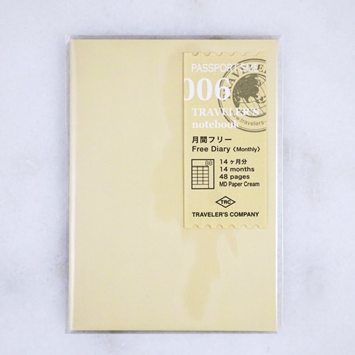 Sealed #006 Undated Monthly (Passport) Traveler's Notebook refill, featuring 48 MD Cream paper pages for 14 months in a compact, passport-sized format.