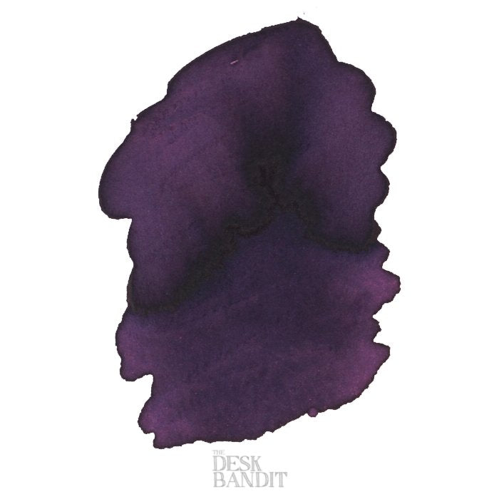 Oval-shaped deep purple ink swatch on white, branded THE DESK BANDIT, representing Robert Oster's Purple Rock - 2ml dye-based ink sample.