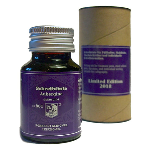 Rohrer & Klingner Aubergine (2018 Limited Ed) fountain-pen ink in a purple-labeled glass bottle, alongside its cylindrical cardboard packaging.