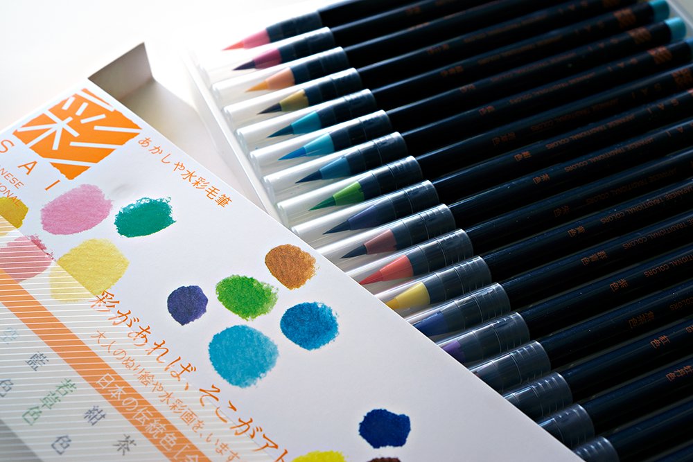 Sai Watercolour Brush Pens - 20 colours, featuring black barrels and vibrant brush tips, displayed alongside a color-sample sheet with Japanese text and brand name SAI.