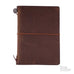 Passport Leather Cover (Brown), a dark-brown leather journal with a metal button and elastic closure, featuring a The Desk Bandit logo in the corner.