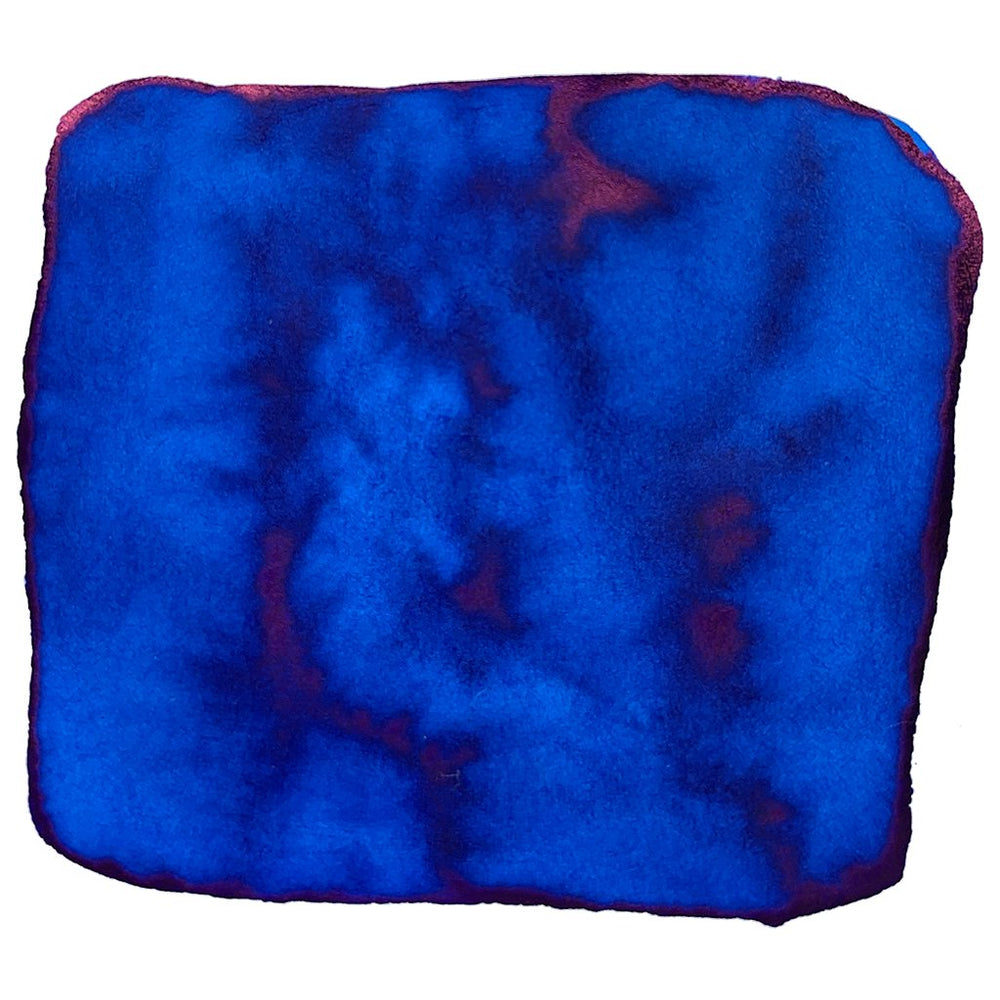 True Blue - 50ml ink swatch showing a vibrant cobalt-to-royal blue wash with deeper pigment veins and a reddish-purple sheen along the edges.