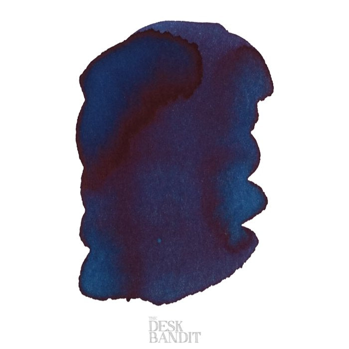 Iroshizuku Ink - Tsuki-yo (2ml) sample featuring a deep blue-teal ink swab with a reddish sheen, branded with The Desk Bandit watermark.