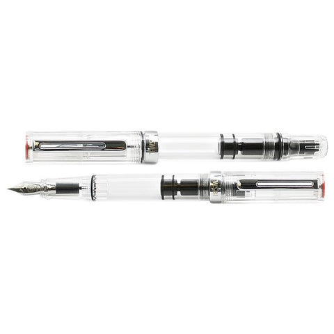TWSBI ECO (Clear) - Broad fountain pen, disassembled, showcasing a transparent barrel with piston mechanism, metal nib section, and cap with metal clip and red gasket.