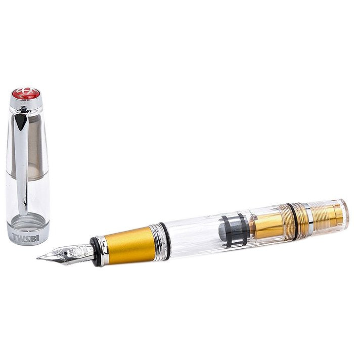 Diamond Mini AL (Gold) - Fine fountain pen with transparent barrel, built-in piston-filling mechanism, gold grip, stainless-steel nib, and clear cap featuring red TWSBI logo.
