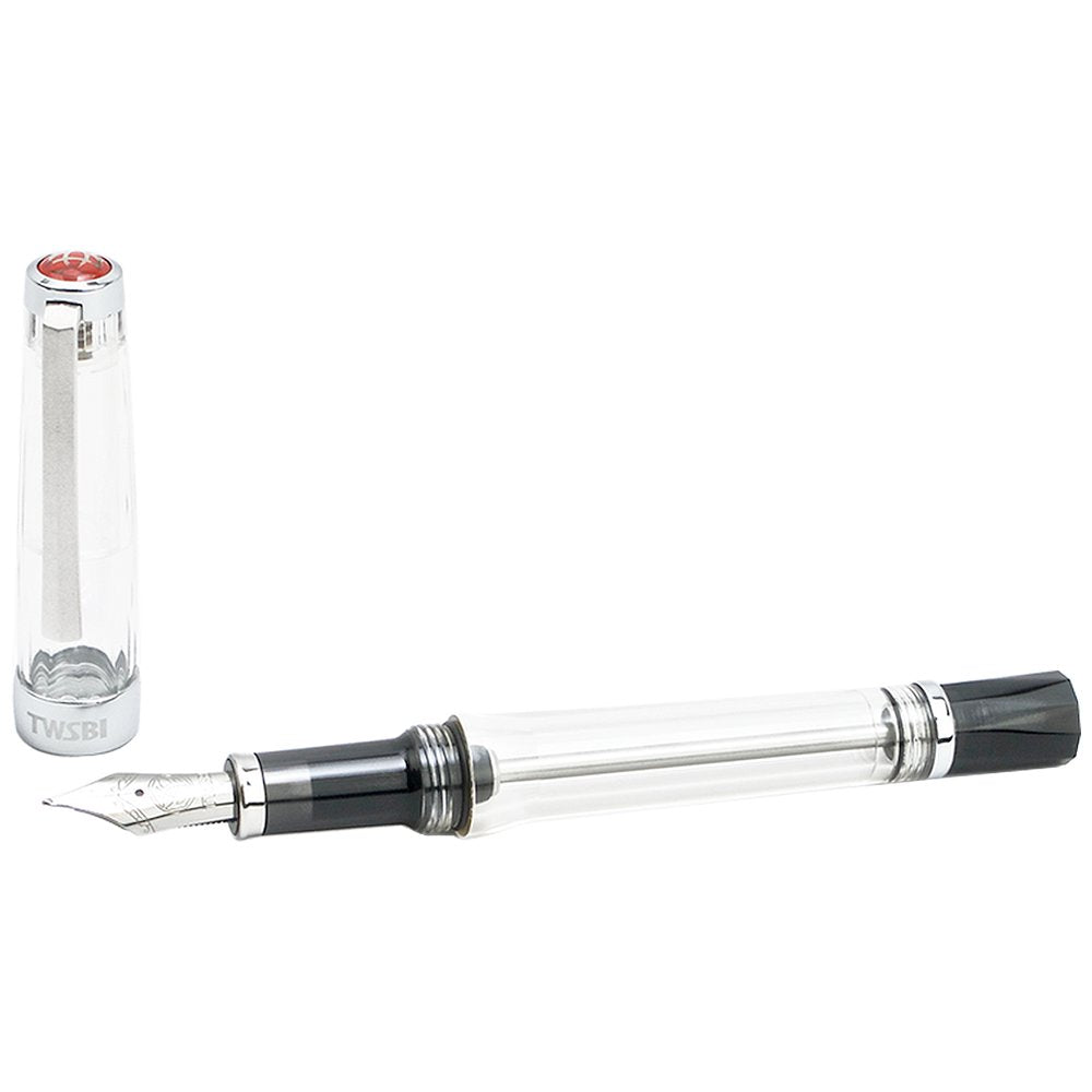 VAC 700R (Clear) - Extra Fine fountain pen with a transparent body, visible metal nib, and branded TWSBI cap beside it, showcasing its vacuum ink reservoir.