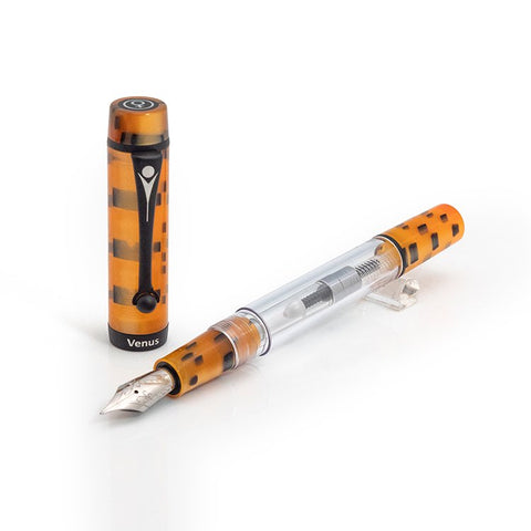 Planet Series (Venus) - Medium fountain pen disassembled; features an orange-and-black mottled acrylic cap, clear barrel showing ink-feed, and stainless steel nib.