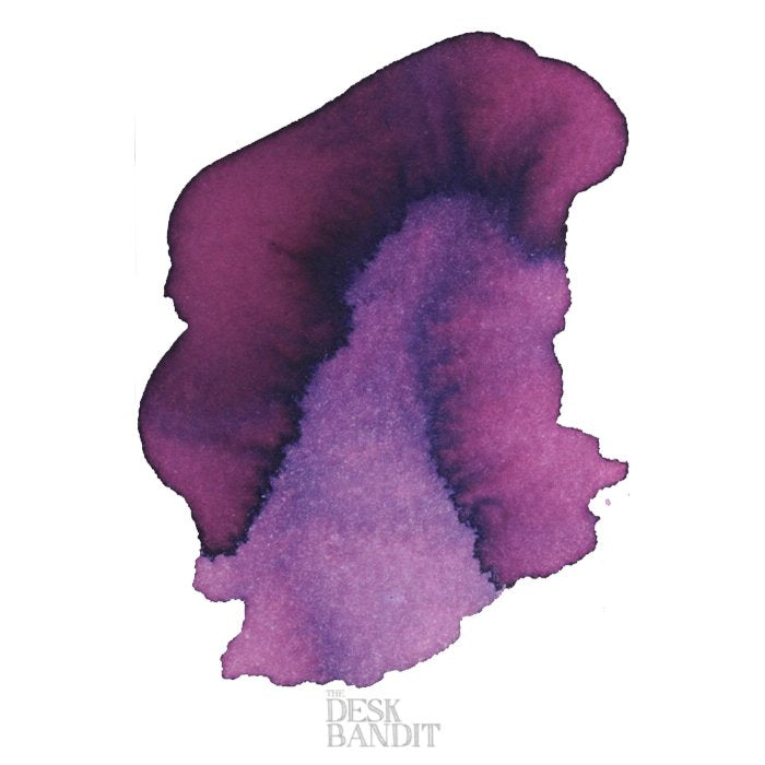Viola - 2ml ink sample by Robert Oster, featuring a free-form swatch blending deep plum to lavender tones on a white background, with The Desk Bandit logo.